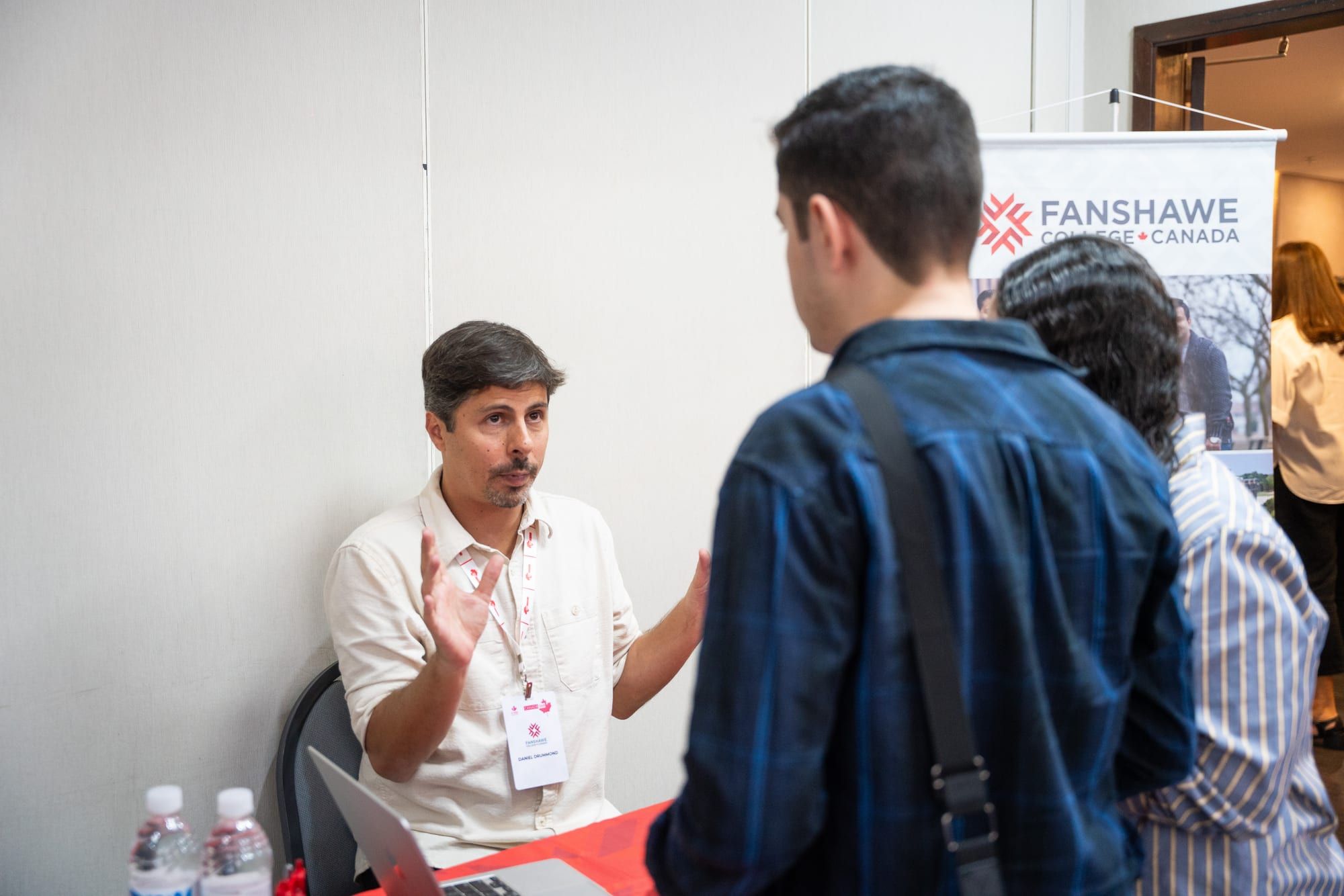 Participante conversando com representante de instituição canadense