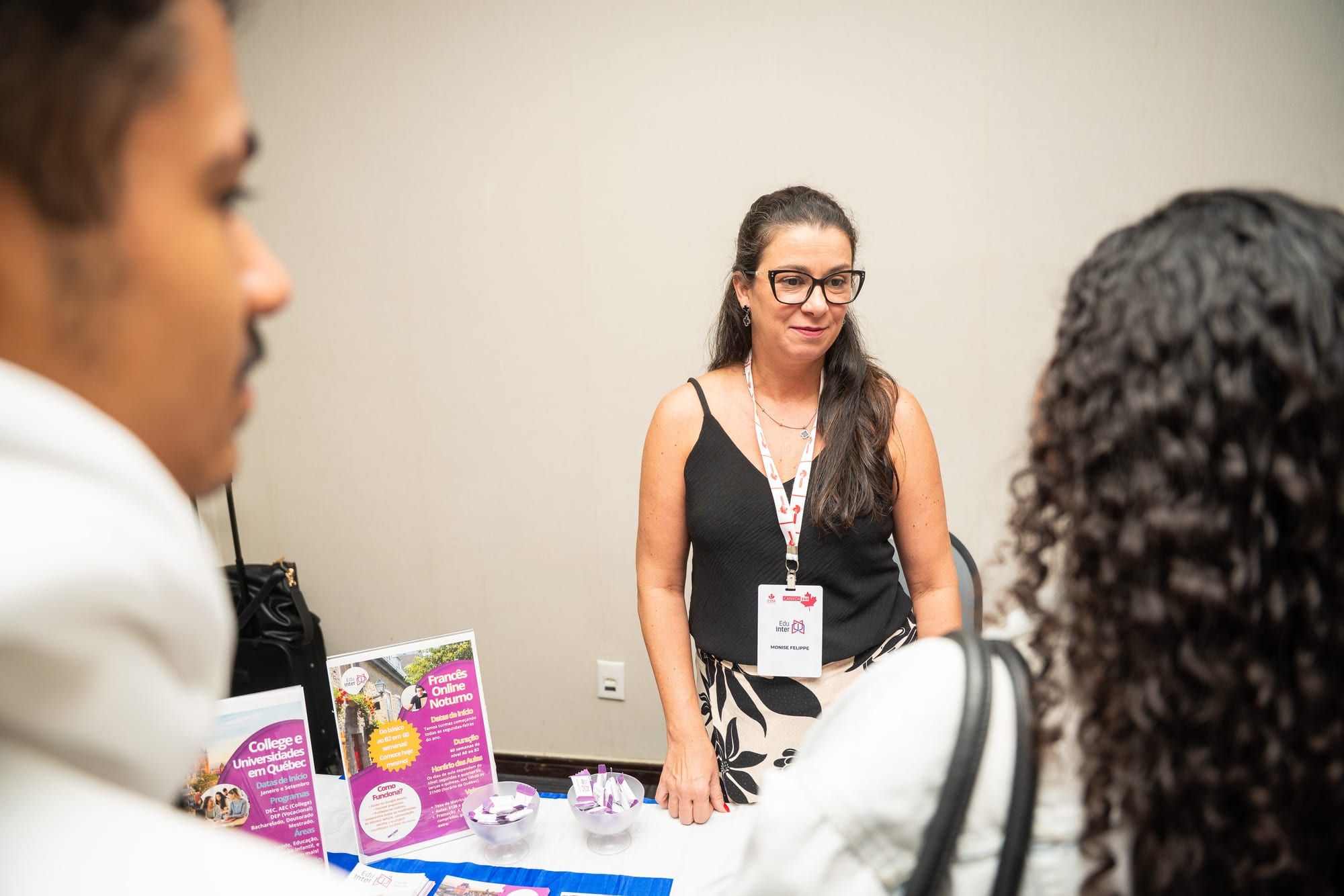 Participantes conversando com representantes de instituições nos estandes