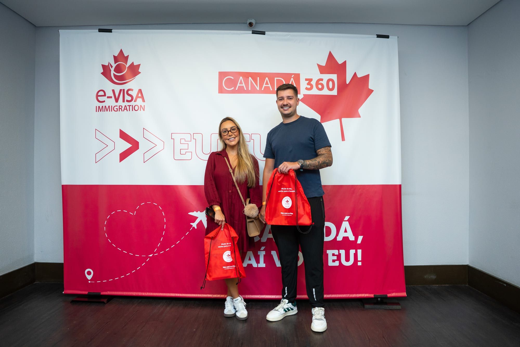 Casal tirando foto diante do painel Canadá, aí vou eu
